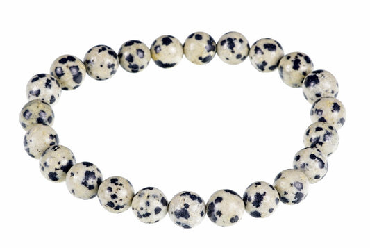 A bracelet made of round beads with a cream background and dark spots, arranged in a circle on a white surface.