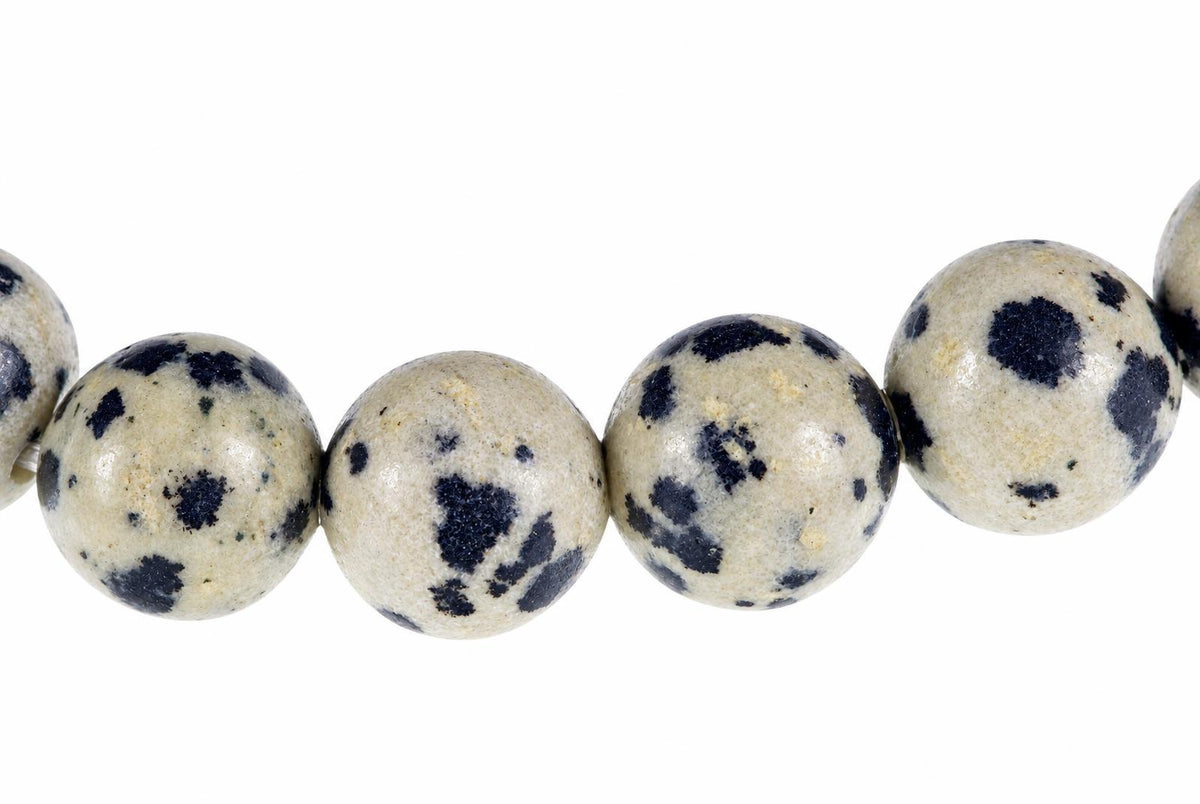 A row of round beads with a pale cream base and dark blue spots, arranged horizontally on a white background.