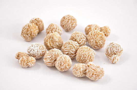 Several round, beige stones with white crystalline textures scattered on a pale surface.