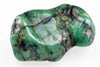 A polished, irregularly shaped stone with green, white and dark veins, resting on a pale surface.