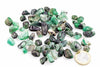 A pile of small, rough green stones with black and white inclusions on a white surface next to a one euro coin.