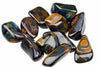 A pile of polished, smooth stones with dark blue and brown banding on a white background.