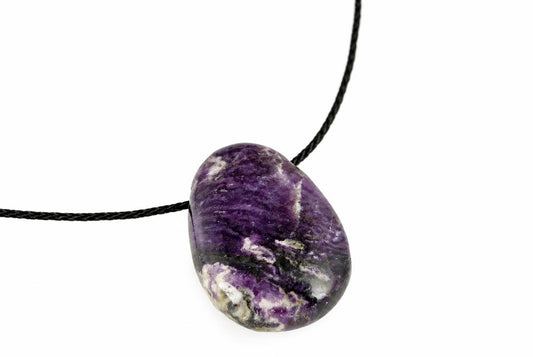 A polished purple and white fluorite pendant on a black cord against a white background.
