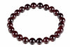 A bracelet made of round, polished dark red beads arranged in a circle on a white background.
