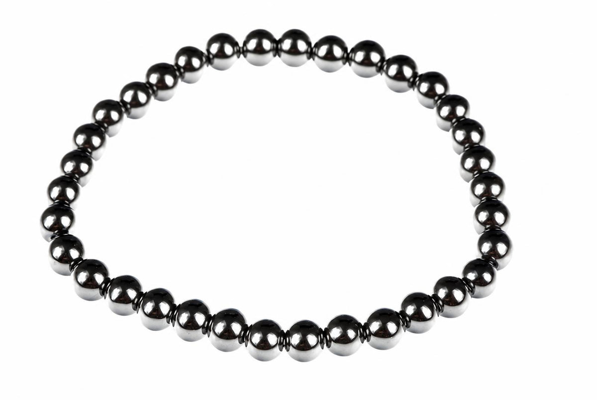A bracelet made of round, dark metallic beads arranged in a circle on a white background.