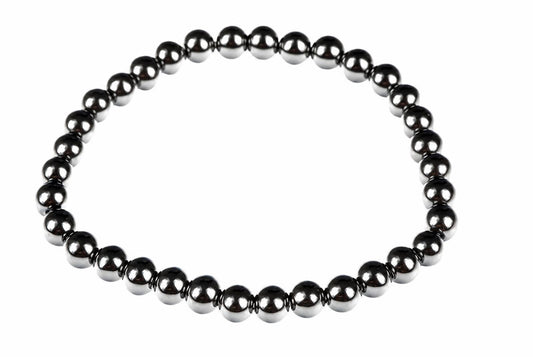 A bracelet made of round, dark metallic beads arranged in a circle on a white background.