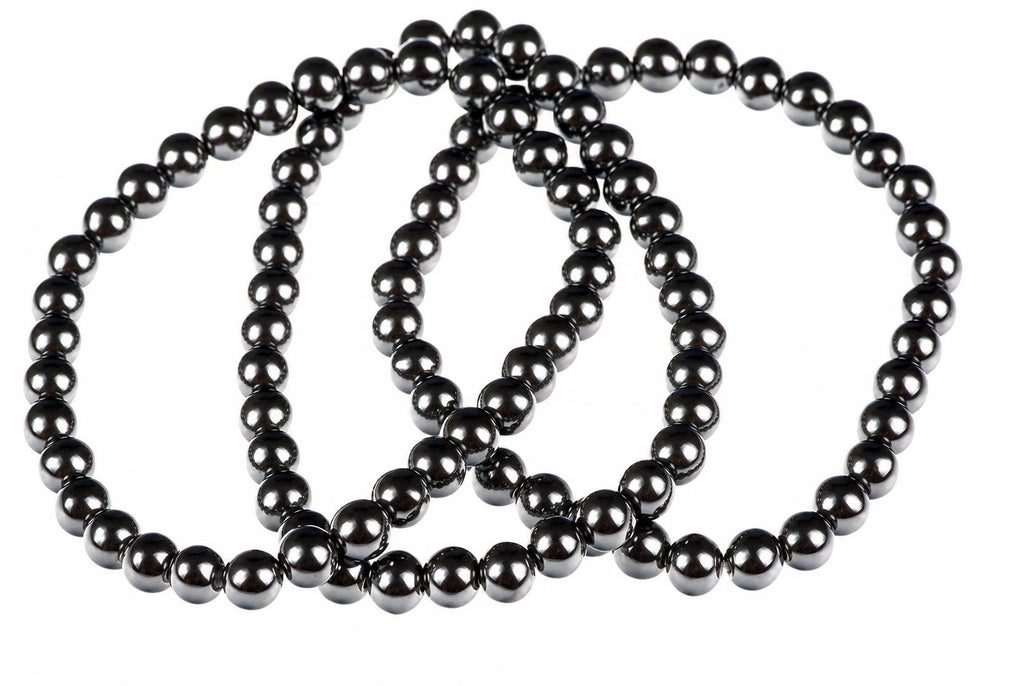 A dark, metallic bracelet made of round beads arranged in a loop on a white background.