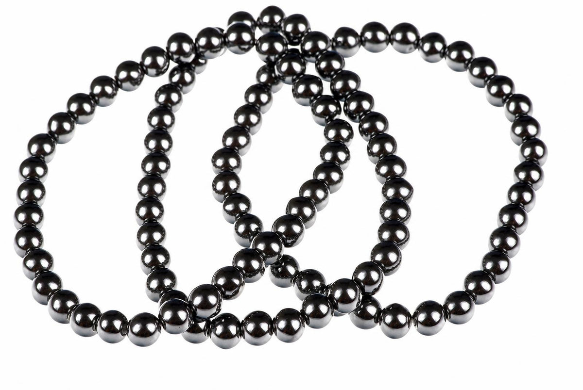 A dark, metallic bracelet made of round beads arranged in a loop on a white background.