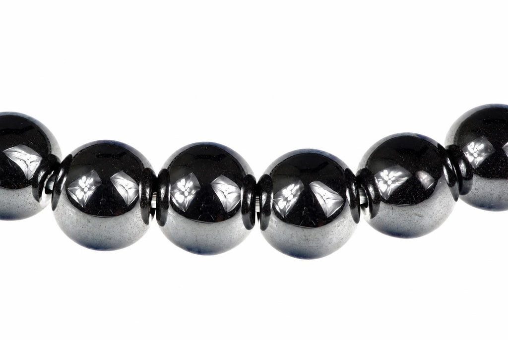 A row of round, dark beads with silver-toned floral inlays on a white background.