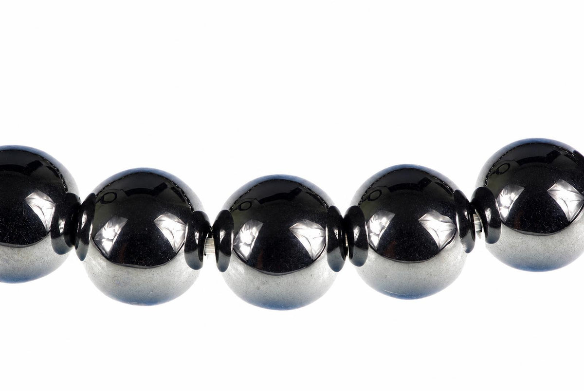 A row of round, dark beads with silver-toned lower halves and small black spacers on a white background.