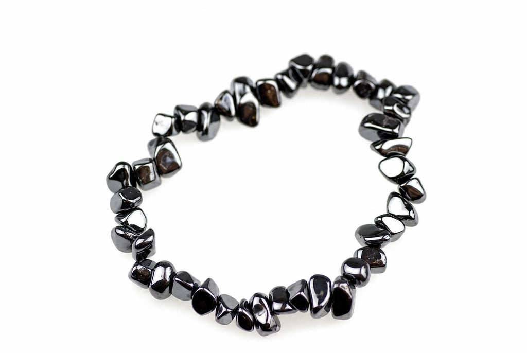 A bracelet made of dark, polished chips arranged in a circle on a white surface.