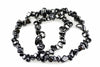 A black and silver-toned Hematite chip bracelet coiled on a white surface.