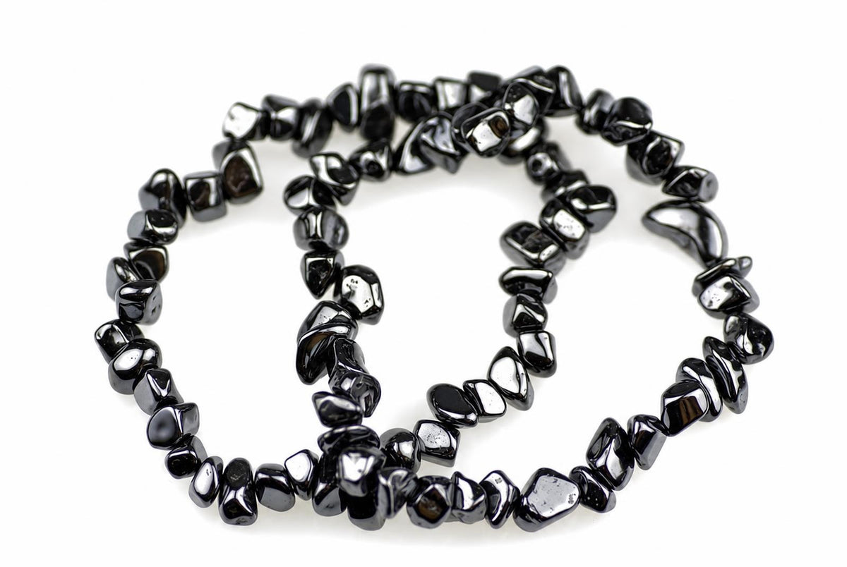 A black and silver-toned Hematite chip bracelet coiled on a white surface.