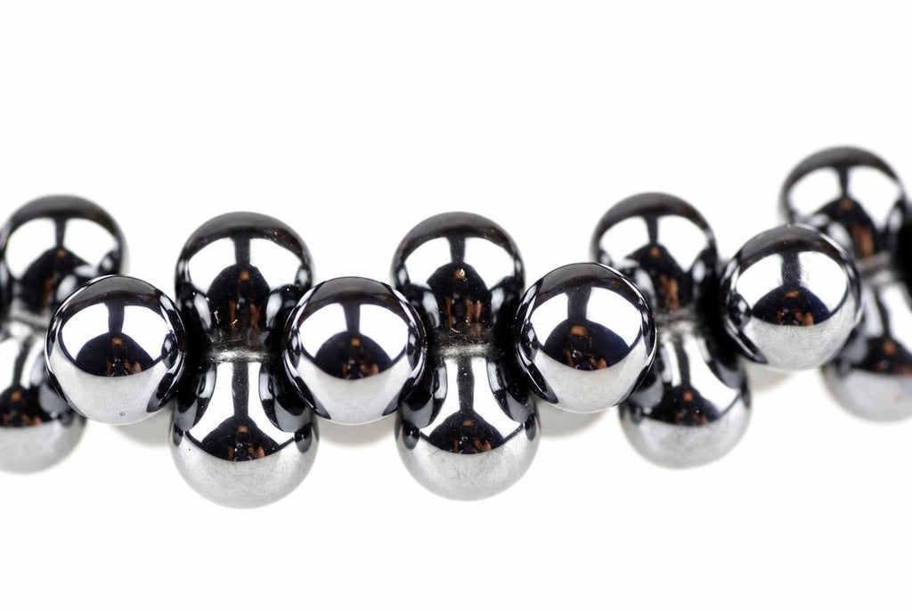 A bracelet with shiny, dark silver-toned spherical beads arranged in a row on a white background.