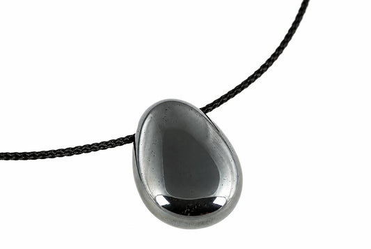 A polished dark grey hematite drop pendant hangs from a black cord, with bright reflections along its rounded lower edge.