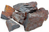 A pile of raw hematite rocks with dark grey and rusty brown surfaces on a white background.