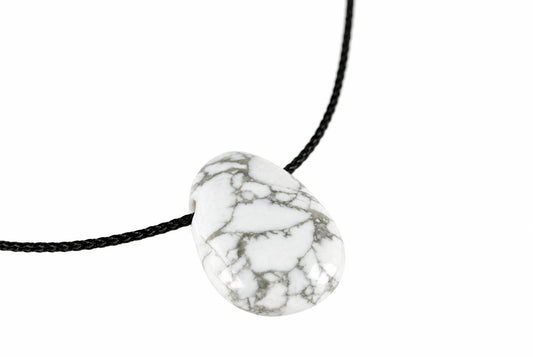 A white pendant with grey veining hangs from a black cord against a plain background.