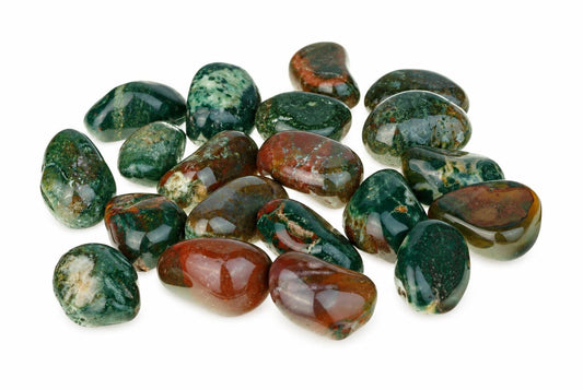 A pile of polished Irai jasper stones with green, red and white patterns on a white surface.
