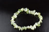 A bracelet made of irregular chips in pale green and white, arranged in a circle on a dark surface.