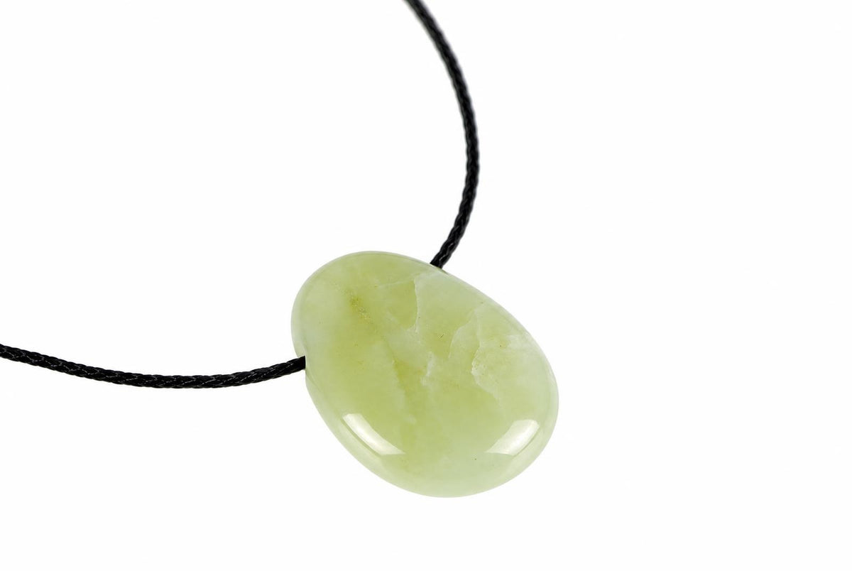 A smooth, oval-shaped pendant in pale green stone hangs from a black cord against a white background.
