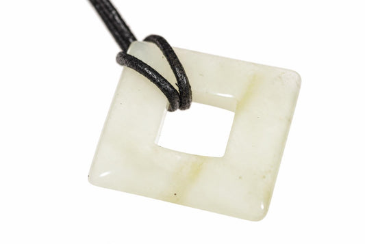 A square jade pendant with a central hole, pale greenish-white in colour, threaded on a black cord against a white background.