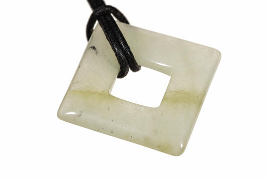 A square jade pendant with a central hole, pale green and white tones, on a black cord against a white background.