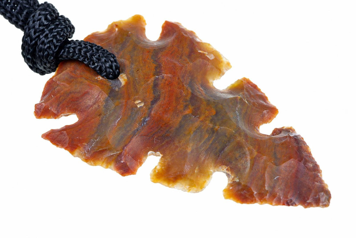 A jasper pendant shaped like an arrowhead, featuring dark brown and orange tones with a black cord loop.