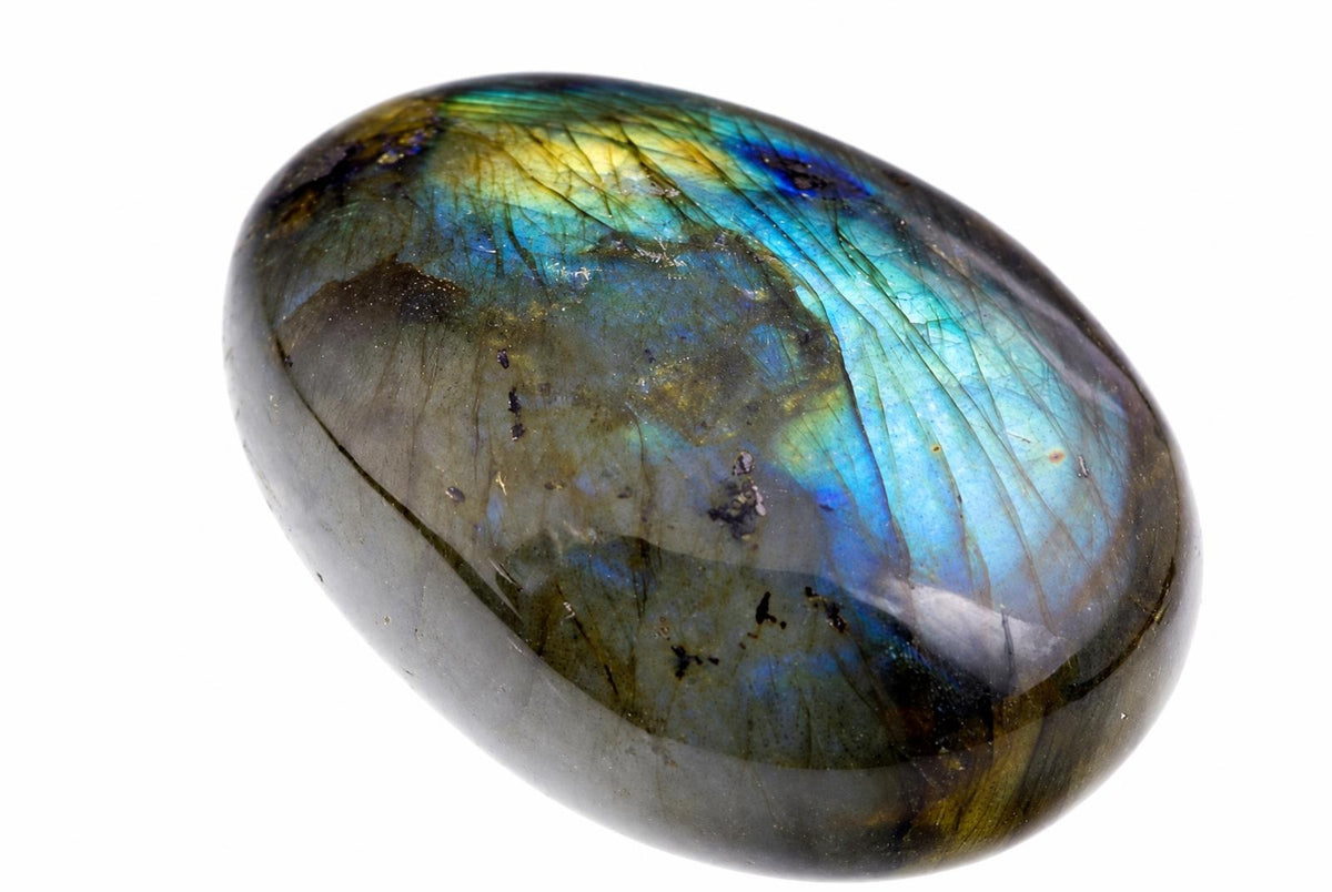 A smooth oval grey-green stone shows a broad blue-green and golden sheen with fine dark lines on white.
