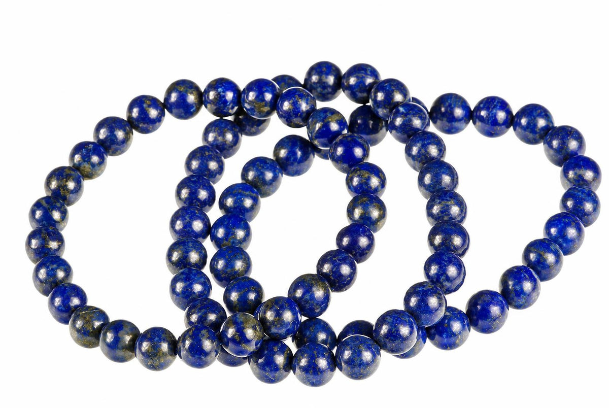 Overlapping bracelets of round blue beads with pale patches and fine gold-toned speckles rest on white.
