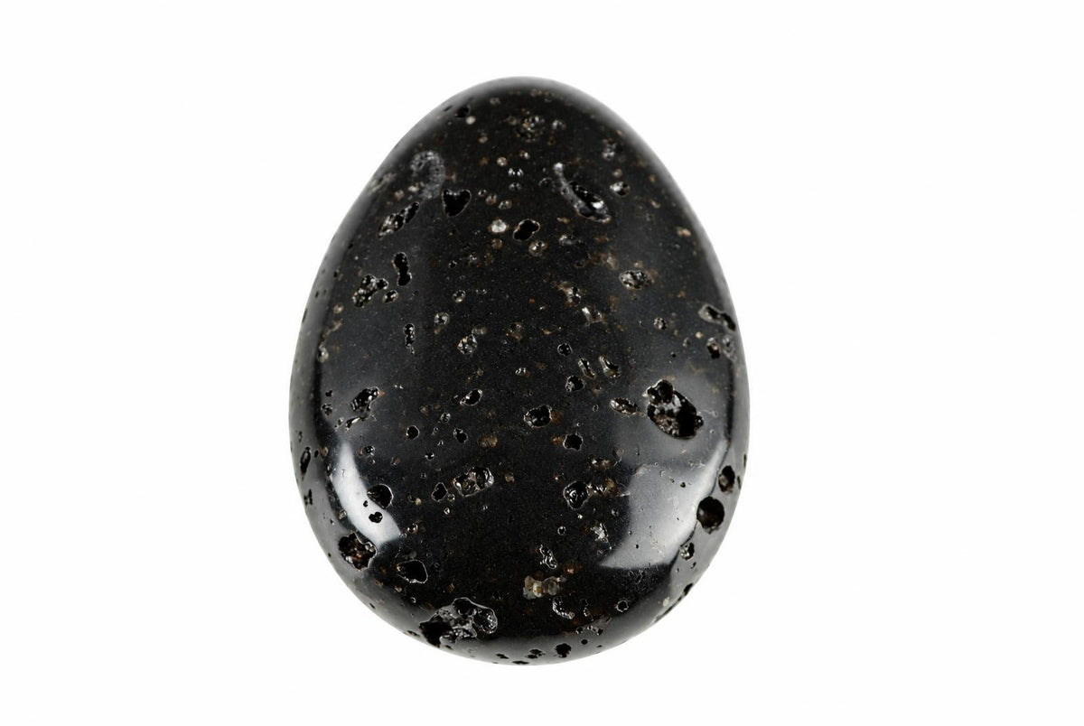 A polished black lava stone pendant with a smooth, egg-like shape and numerous small holes on its surface against a white background.