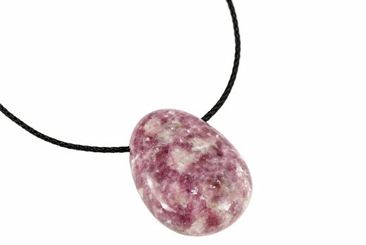 A polished oval pendant with pink and white speckled stone on a black cord against a white background.