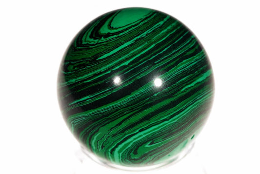 A polished sphere with swirling green and black bands, resting on a clear stand against a white background.