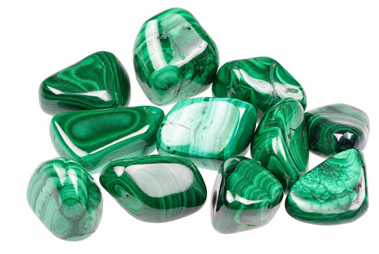 A pile of polished malachite stones with green and white banding on a white background.