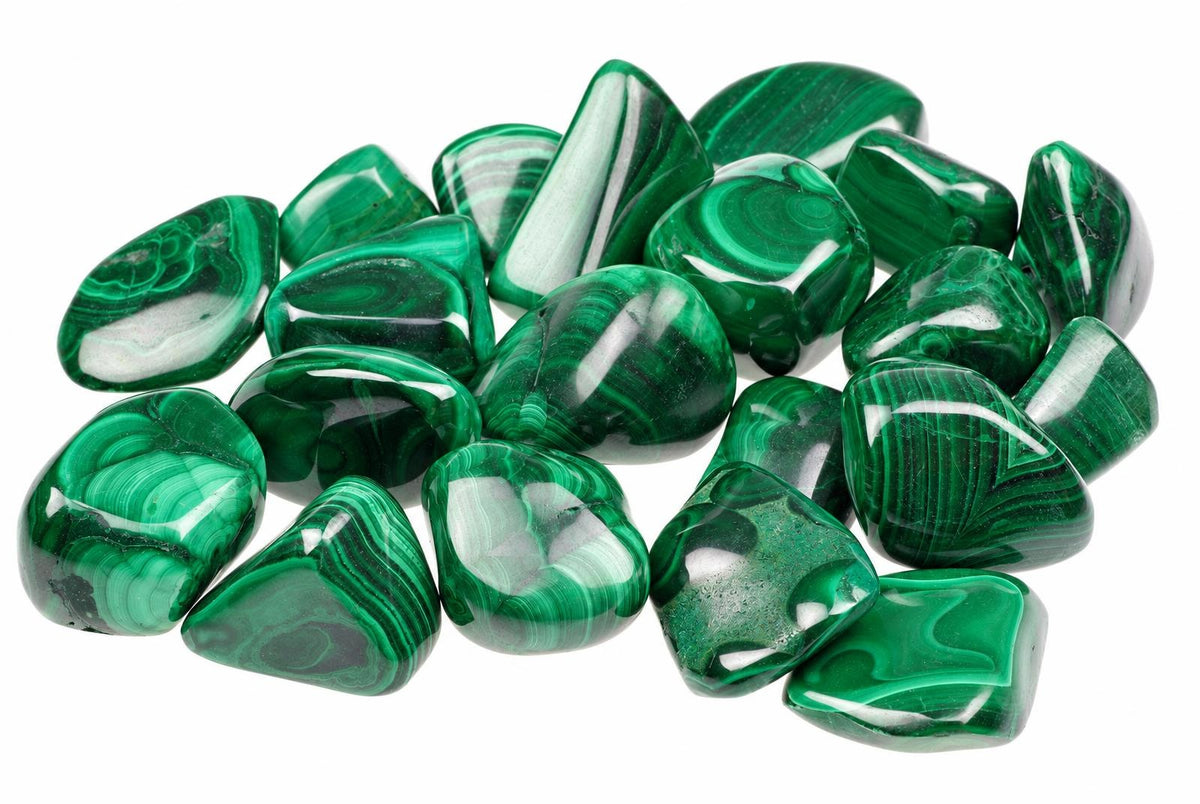 A pile of polished malachite stones with green and white banding on a white background.