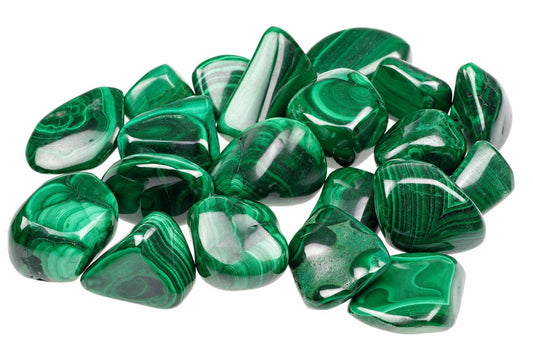 A pile of polished malachite stones with green and white banding on a white background.