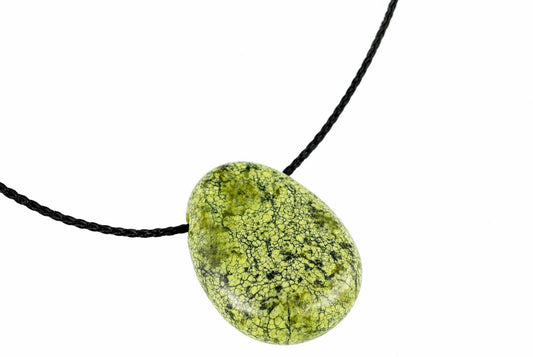 A green and black patterned oval pendant on a dark cord against a white background.