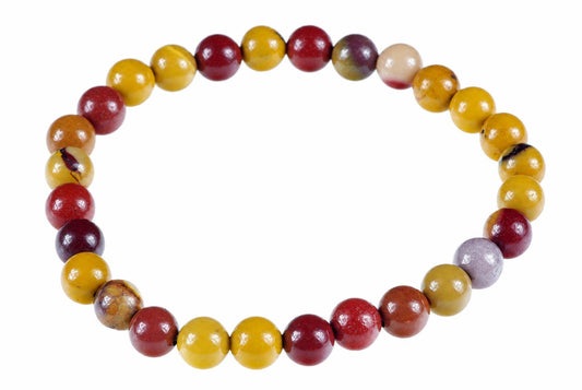 A bracelet of round beads in red, yellow, and purple tones arranged on a white surface.