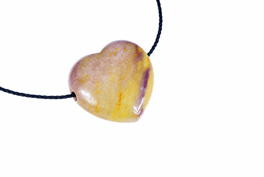 A heart-shaped pendant with a polished, variegated surface of yellow, pink and purple tones on a dark cord against a white background.