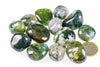 A collection of polished moss agate stones with green and white patterns, arranged on a pale surface next to a one-euro coin.