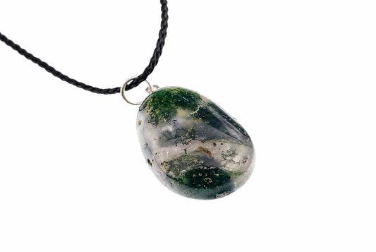 A silver-toned ring connects a black cord to an oval, translucent pendant containing green moss-like inclusions on a pale surface.