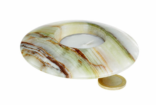 A round pale green and cream stone candle holder with brown bands and a recessed center sits beside a coin on a white background.