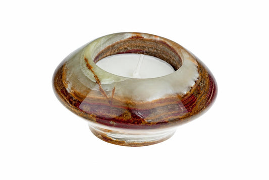 A polished, UFO-shaped candle holder with swirling bands of brown, red, and pale green stone holds a white tea light on a white background.
