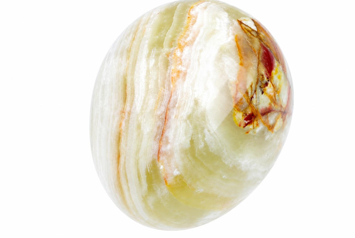 A polished, egg-shaped stone with white and pale green swirls, accented by reddish-brown veins on a plain background.