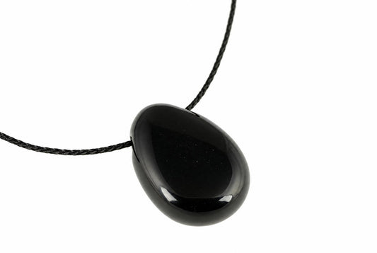 A black, teardrop-shaped pendant with a smooth surface hangs from a dark cord against a white background.