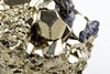 A close-up of a pyrite specimen with golden, metallic crystals and dark blue-grey mineral inclusions on a white background.