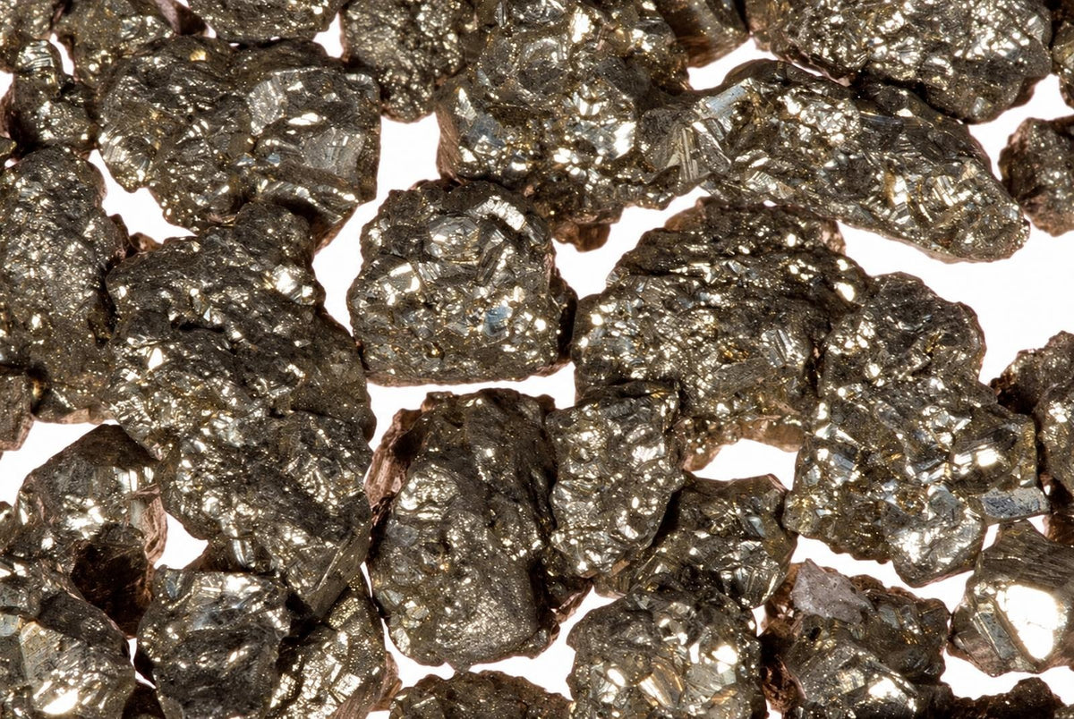 A pile of small, metallic, gold-coloured and silver-toned pyrite mineral chunks on a white background.