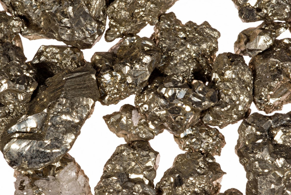 A pile of small, metallic gold-coloured pyrite mineral specimens with a brassy sheen on a white background.