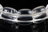 A close-up of a bracelet with large, clear quartz beads featuring frosted horizontal bands, set against a dark surface.