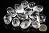 Twelve clear quartz stones on a dark surface with a one euro coin for scale.