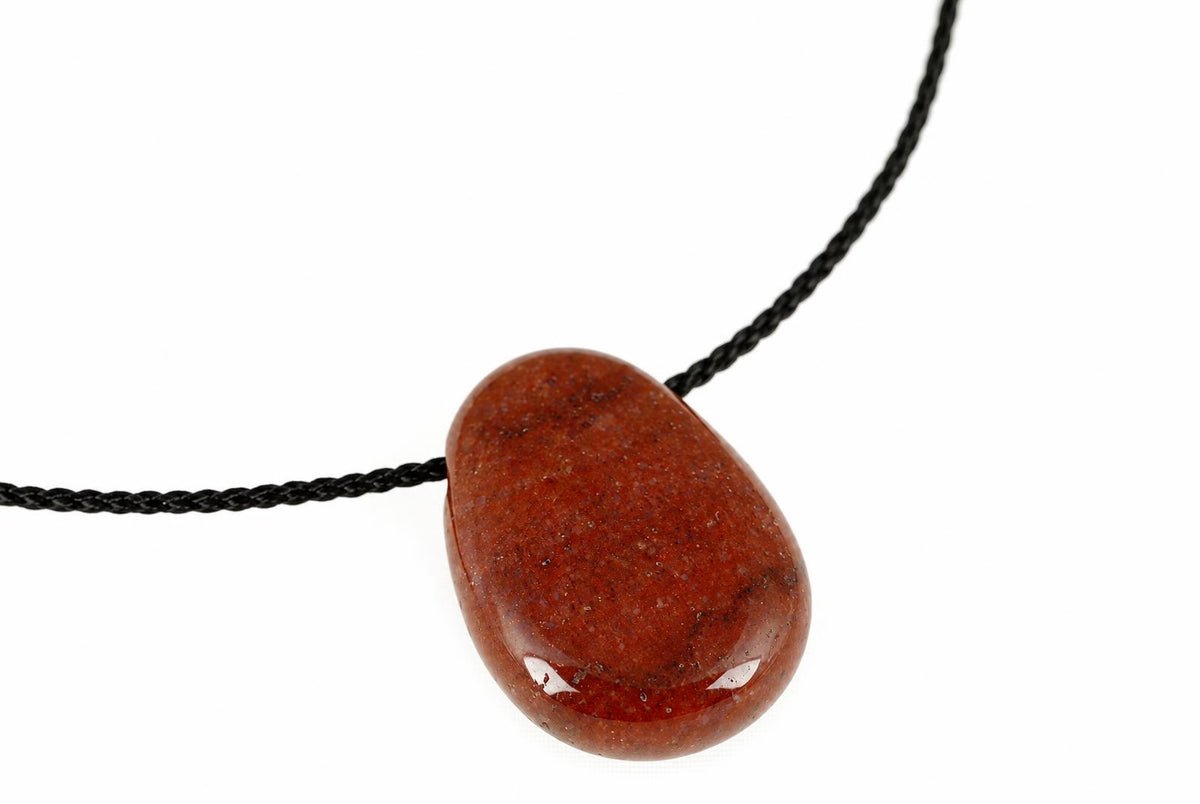 A polished, reddish-brown teardrop-shaped pendant on a black cord against a white background.